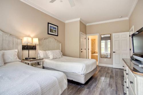 une chambre avec deux lits et une télévision à écran plat dans l'établissement Stunning Litchfield 2BR Condo at Seaside Inn, à Pawleys Island
