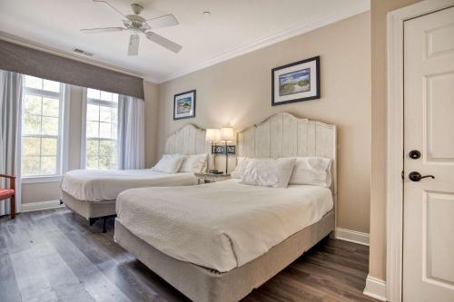 une chambre avec deux lits et un ventilateur de plafond dans l'établissement Litchfield 1BR Getaway at Seaside Inn, à Pawleys Island