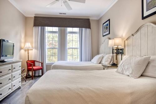 une chambre d'hôtel avec deux lits et une télévision dans l'établissement Litchfield 1BR Getaway at Seaside Inn, à Pawleys Island