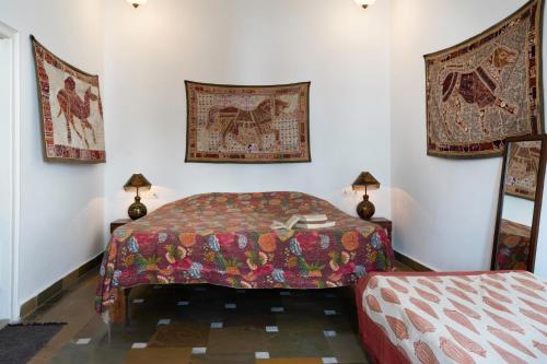 a bedroom with a bed and two pictures on the wall at Lake Pichola Hibiscus Hotel in Udaipur