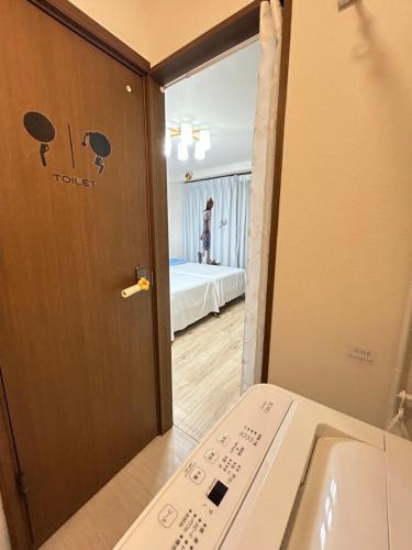 a bathroom with a door open to a room at Petit Asahi in Kobe
