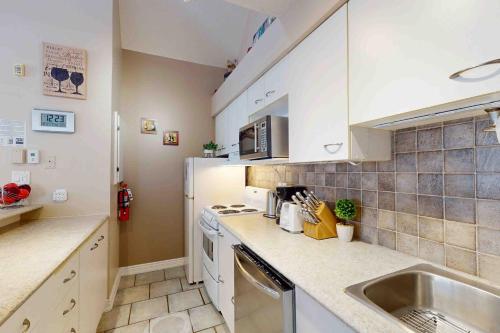 a small kitchen with a sink and a stove at Condo 713 at North Creek Resort in Blue Mountains
