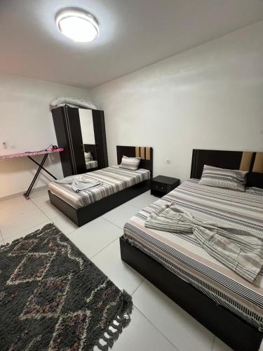 エル・アラメインにあるchalet for rent in marina marassiのラグ付きの部屋のベッド2台