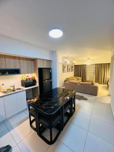 エル・アラメインにあるchalet for rent in marina marassiのキッチン、リビングルーム(黒いカウンタートップ付)
