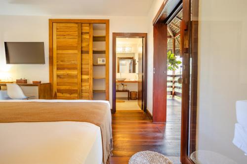 a bedroom with a bed and a desk in a room at Aldeia Jericoacoara - Suites Privativas in Jericoacoara