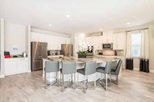 cocina con mesa de comedor grande con sillas en Fabulous Home With Air Hockey, Media Room And Waterpark & Resort Access Near Disney At Encore Resorts Reunion - 290Fl, en Kissimmee