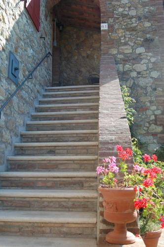 a set of stairs in front of a building with flowers at Agriturismo San Ansanino- Piscina con spiaggia-Aria condizionata in Pari