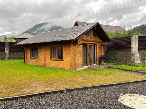 a small wooden house with a table in front of it at Еко будинок Duet in Maydan