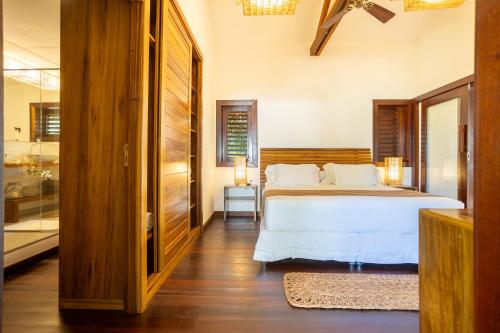 a bedroom with a bed with white sheets and pillows at Aldeia Jericoacoara - Suites Privativas in Jericoacoara