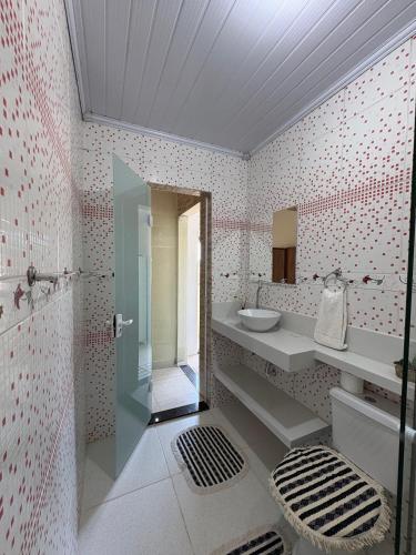 a bathroom with a sink and a mirror at Suítes Carla e Carol in Praia de Araçatiba