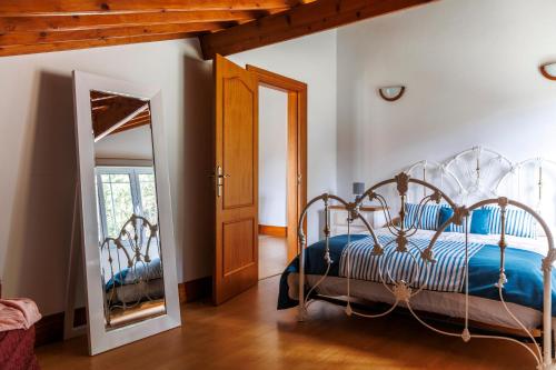 a bedroom with a metal bed and a mirror at Casa do Dízimo in Furnas