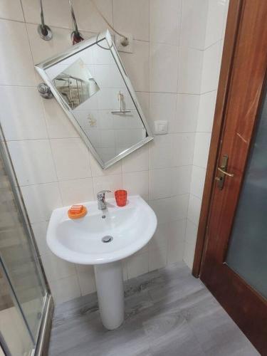a bathroom with a white sink and a mirror at Nice room with private bathroom in Ercolano
