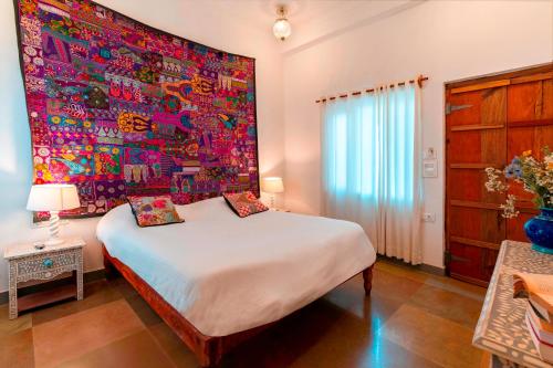 a bedroom with a large painting on the wall at Lake Pichola Hibiscus Hotel in Udaipur