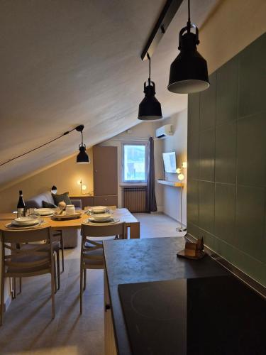a kitchen and living room with tables and chairs at Kalimè in Alba