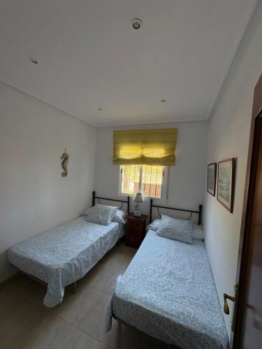 two beds in a small room with a window at Brisa Azul in Playas de Vera
