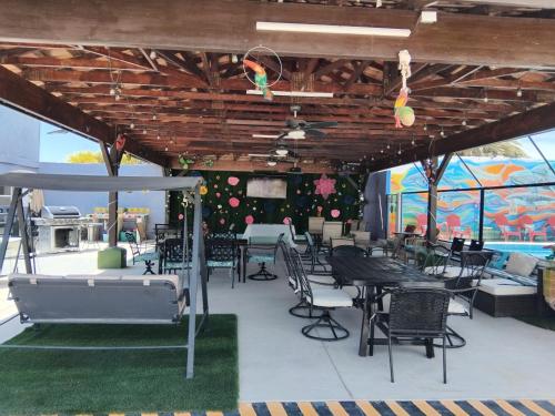 a patio with tables and chairs and a wall of windows at Hotel Casa Victoria in Puerto Peñasco