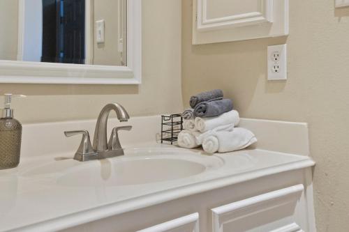 a bathroom with a sink with towels and a mirror at Spacious Retreat for Crews, Corporates & Families in Houston