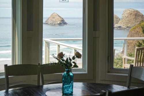 a vase with flowers on a table in front of a window at Berni's Ocean View Castle - an Oceanside Legend in Oceanside