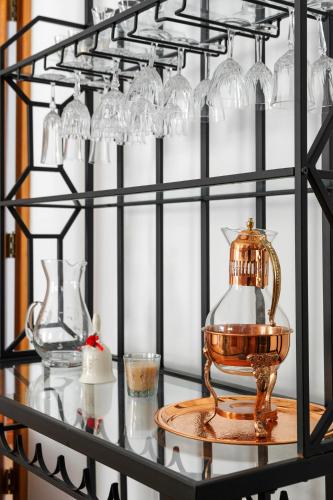 a glass shelf with glasses and a teapot on it at Casa do Dízimo in Furnas