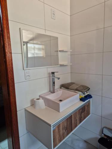 a white bathroom with a sink and a mirror at Eco Cabana Mantiqueira in Queimada