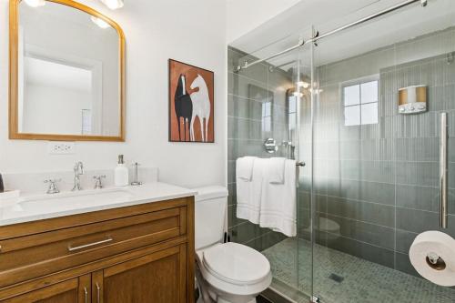 a bathroom with a toilet and a glass shower at Bray House - Epic Shared Backyard - Pool - Games in Phoenix