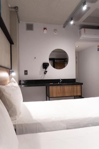 a room with two beds and a mirror at ibis Arcoverde in Arcoverde