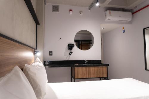 a hotel room with a bed and a mirror at ibis Arcoverde in Arcoverde