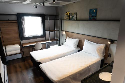 a bedroom with two beds and a window at ibis Arcoverde in Arcoverde