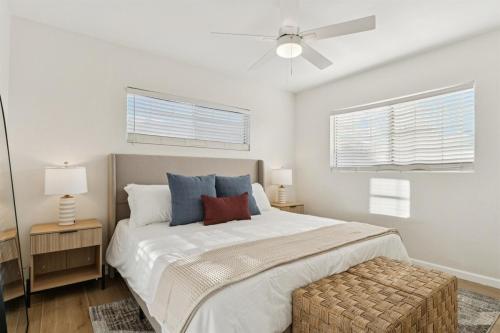 a bedroom with a large bed and two windows at Bray House - Epic Shared Backyard - Pool - Games in Phoenix