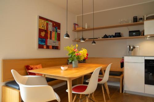 a kitchen with a wooden table and white chairs at SandDorn 1 und 2 in Pruchten