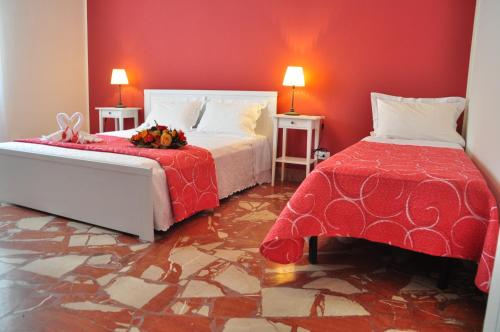 una camera con due letti e una parete rossa di Bet Home a Palermo
