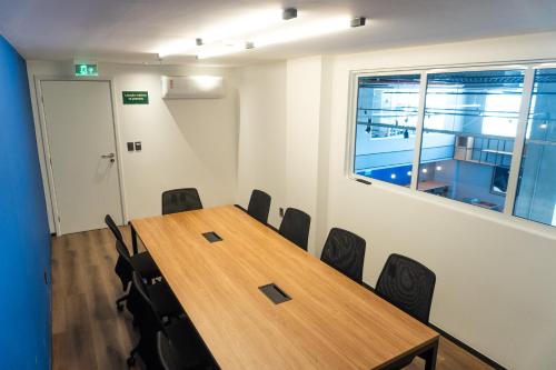 a conference room with a wooden table and chairs at ibis Arcoverde in Arcoverde