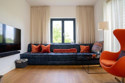 a living room with a blue couch and a television at SandDorn 1 und 2 in Pruchten