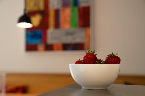 two strawberries in a white bowl on a table at SandDorn 1 und 2 in Pruchten