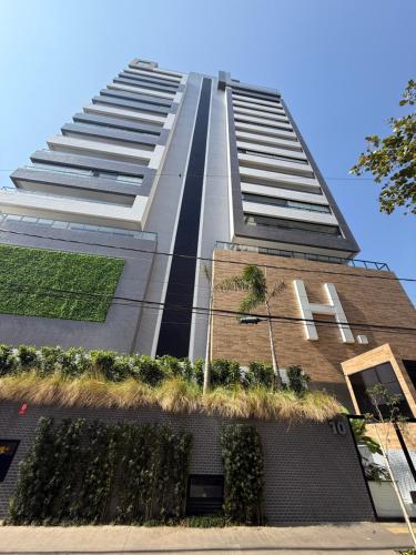 a tall building with plants on the side of it at Santos Comfort - Perto da Praia in Santos