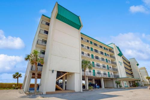 a large building with palm trees in front of it at Emerald Surf 206 in Navarre