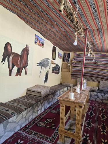 a room with a table and a horse on the wall at Friends of Dana Hotel in Dana