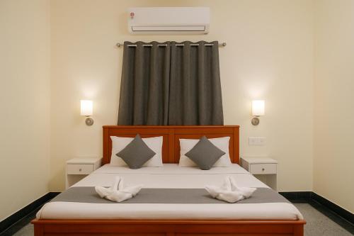 a bedroom with a bed with two pillows at Hotel Urban Eminence Banjara Hills, Near Shri Jagannatha Swami Temple in Hyderabad