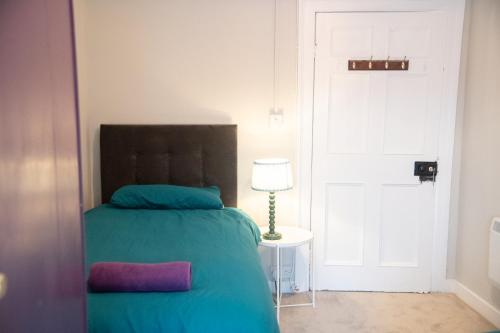 a bedroom with a bed and a lamp and a door at Carrick Central Accommodation in Carrick on Shannon