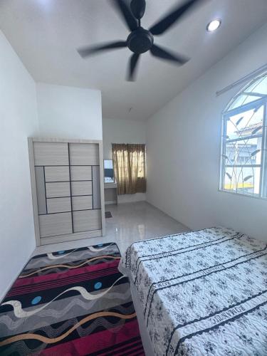 a bedroom with two beds and a ceiling fan at Homestay Manjung Ann in Seri Manjung