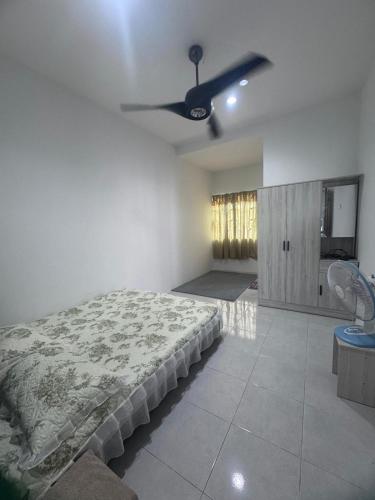 a bedroom with a bed and a ceiling fan at Homestay Manjung Ann in Seri Manjung