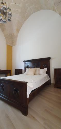 a bedroom with a large wooden bed in a room at HiSalento in Surbo