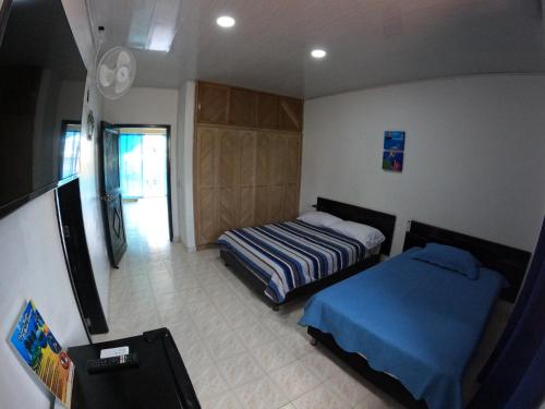 a small bedroom with two beds and a tv at Alojamiento blue castle in San Andrés