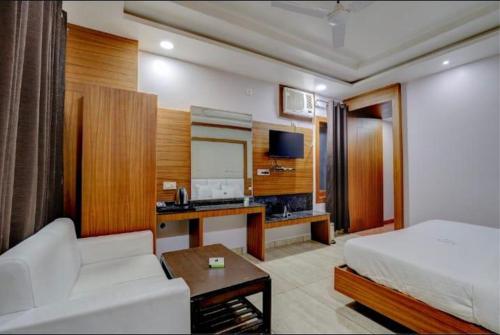 a hotel room with a bed and a couch and a desk at Pushap villa katra in Katra