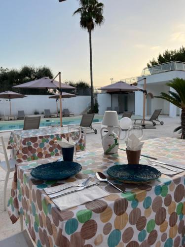 a table with plates on it next to a pool at Castellinaria Holiday in Castellana Grotte