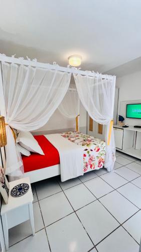 a bedroom with a bed with a canopy at Villa Baobá Pousada & Spa in Búzios
