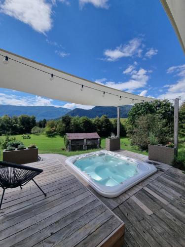 a hot tub sitting on a wooden deck with an umbrella at Apartments Pri Jakobu in Kobarid