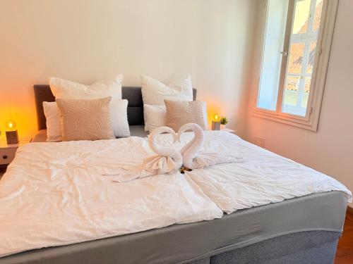 two swans are sitting on top of a white bed at DREAMZzz l Perfekt für Familien & Paare l Innenstadt Coburg l Parkhaus 100 Meter in Coburg