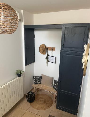 a room with a black cabinet and a chair at Gîte du soleil in Saint-Maurin