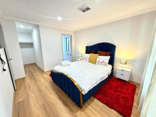 a bedroom with a blue bed and a red rug at Urban Virgo Escape in Caversham